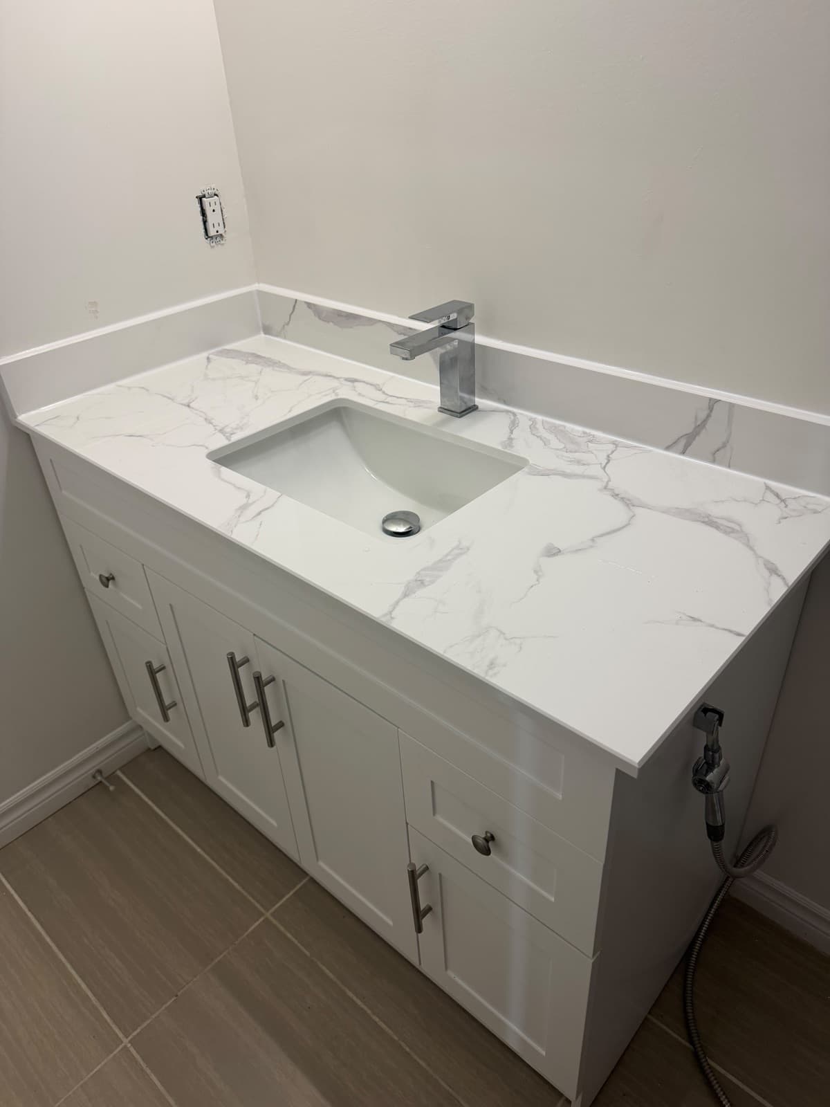 White vanity with marble-look top, undermount sink and chrome faucet